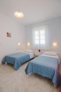 a bedroom with two beds and a window at Athena Rooms in Ios Chora