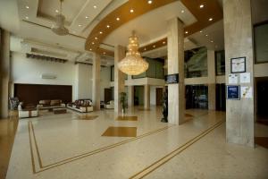 a large lobby with a chandelier in a building at Hotel The Evergrand Palace in Rajkot