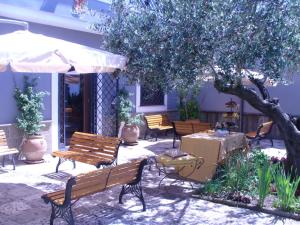 eine Terrasse mit Bänken und Tischen und einem Baum in der Unterkunft Casale Nido dell'Aquila in Squille