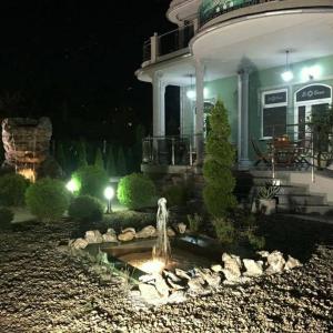 a fountain in front of a house at night at El Barco Apartments in Veliko Gradište