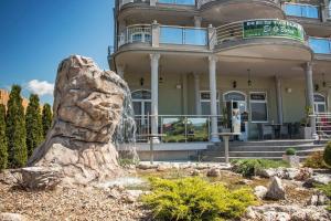 a building with a fountain in front of it at Vila El Barco in Veliko Gradište