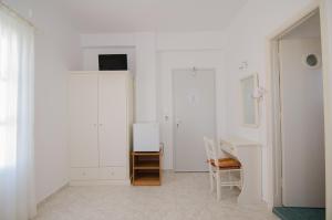 a white room with a desk and a white wall at Athena Rooms in Ios Chora