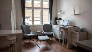 ein Büro mit Stühlen und einem Schreibtisch mit einem Computer in der Unterkunft Apartmán Bubeneč in Prag