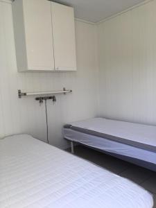 a room with two beds and a white cabinet at Orkla Camping in Orkanger