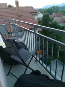 une chaise assise sur le balcon d'une maison dans l'établissement Apartman "Vienna", à Sokobanja