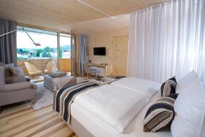 a bedroom with a large bed and a living room at Tannenhof Sport & SPA in Weiler-Simmerberg