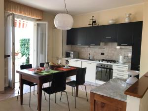 uma cozinha com mesa e cadeiras e uma cozinha com armários pretos em Suite Francy Panorama em Bardolino