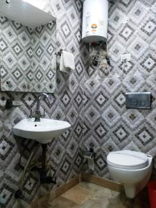 a bathroom with a white toilet and a sink at Hotel Laxman Resort by The Golden Taj Group &Hotels in Agra