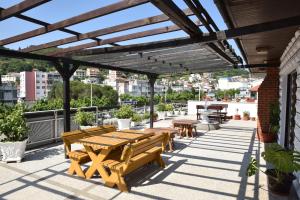 een patio met houten banken en tafels op een dak bij Guest House Evropa in Ulcinj