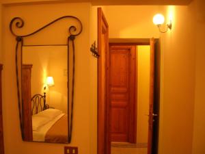 um espelho pendurado numa parede ao lado de um quarto em Maison de Marta em Roma