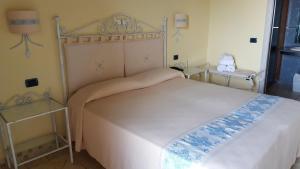 a bedroom with a bed with a white bedspread at Hotel Corsaro Nero in Portu Maga