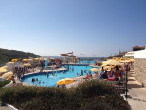 a large swimming pool with people in the water at Sintra Sol - Apartamentos Turisticos in Sintra