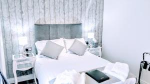 a bedroom with a large bed with white sheets and pillows at Number 4 in Derry Londonderry