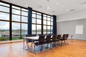 una sala conferenze con tavolo, sedie e finestre di Lindesnes Havhotel a Spangereid