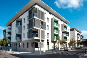 an apartment building with balconies on a street at Domitys Sophia in Nîmes