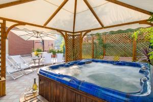 a hot tub on a patio with an umbrella at Barchi Resort - Apartments & Suites in San Felice del Benaco