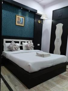 a bedroom with a large bed with a blue wall at Hotel Laxman Resort by The Golden Taj Group &Hotels in Agra