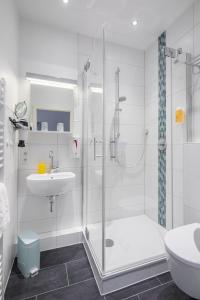een badkamer met een douche, een toilet en een wastafel bij Gästehaus Bakker in Norderney