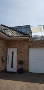 a brick house with two white garage doors at Achim bei Bremen gemütlich wohnen in Achim