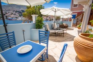 a blue table and chairs and an umbrella on a patio at Villa Galanis in Symi