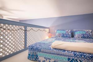 a blue bedroom with a bed and a balcony at Villa Galanis in Symi