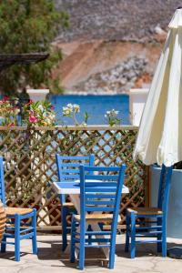 two blue chairs and a table and an umbrella at Villa Galanis in Symi