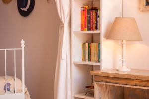 a room with a crib and a lamp and books at Villa Galanis in Symi