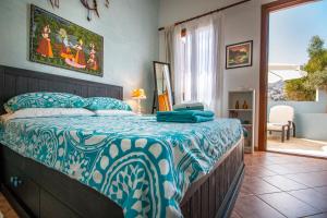 a bedroom with a bed with a blue and white comforter at Villa Galanis in Symi