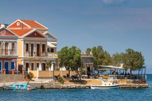 a house on the water with boats in the water at Villa Galanis in Symi
