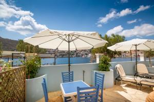 a patio with tables and chairs and umbrellas at Villa Galanis in Symi