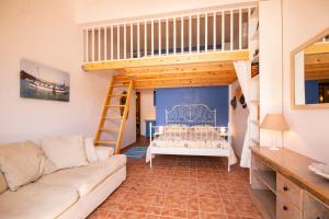 a living room with a couch and a loft bed at Villa Galanis in Symi