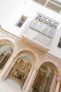 a building with arches and windows with a chandelier at Dar El Jeld Hotel and Spa in Tunis