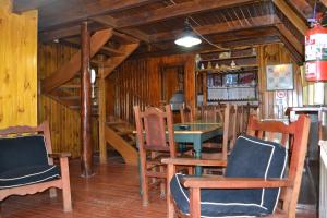 Habitación con sillas de madera, mesa y escaleras. en Cabañas Bosque Del Faldeo en Ushuaia