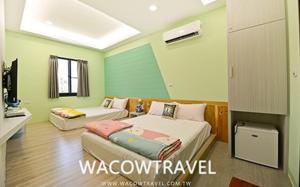 two beds in a room with green walls at Mann Liuqiu Homestay in Xiaoliuqiu