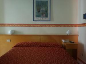 um quarto com uma cama vermelha e uma fotografia na parede em Villa Athena em Giardini Naxos