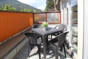una mesa negra y sillas en el balcón en FeWo Nicky by Isa Bad Kleinkirchheim en Bad Kleinkirchheim