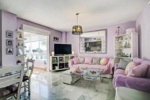 a pink living room with a couch and a table at Andalhue Apartment in Marbella