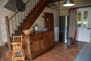 a kitchen with a staircase and a refrigerator at Domaine d azac in Usson-du-Poitou