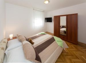 a bedroom with a bed with a teddy bear on it at Breki Apartman in Podstrana