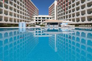 una gran piscina frente a dos edificios en Ukino Palmeiras Village - 24h All Inclusive, en Armação de Pêra