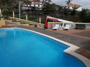 a blue swimming pool with chairs and a bus at STUDIO'S HOUSE in Funchal