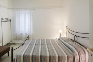 ein Schlafzimmer mit einem großen Bett und einer gestreiften Decke in der Unterkunft Taormina Sunny Experience in Taormina