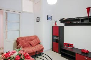 ein Wohnzimmer mit einem Stuhl und einem Entertainment-Center in der Unterkunft Taormina Sunny Experience in Taormina