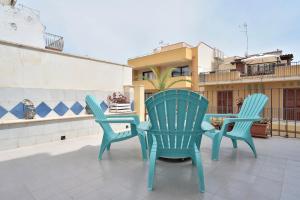 three green chairs and a table on a patio at Terrazza sul Corso in Pozzallo