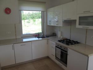 a kitchen with white cabinets and a sink and a window at Eol in Karpacz