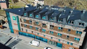 une vue de tête sur un grand bâtiment en briques avec une camionnette devant dans l'établissement Font D'Argent Canillo, à Canillo