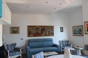 a living room with a blue couch and two chairs at Seaview Apartment Monterosso, Cinque Terre in Monterosso al Mare