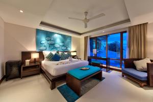 a bedroom with a bed and a couch and a window at Lotus Samui Luxury Beach Villas in Mae Nam