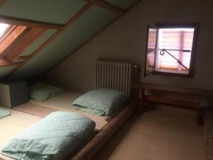サン・ジェルヴェ・レ・バンにあるLes Cristauxのベッド2台と窓が備わる屋根裏部屋です。