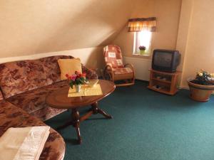 - un salon avec un canapé, une table et une télévision dans l'établissement Fischhus Bormann, à Sassnitz